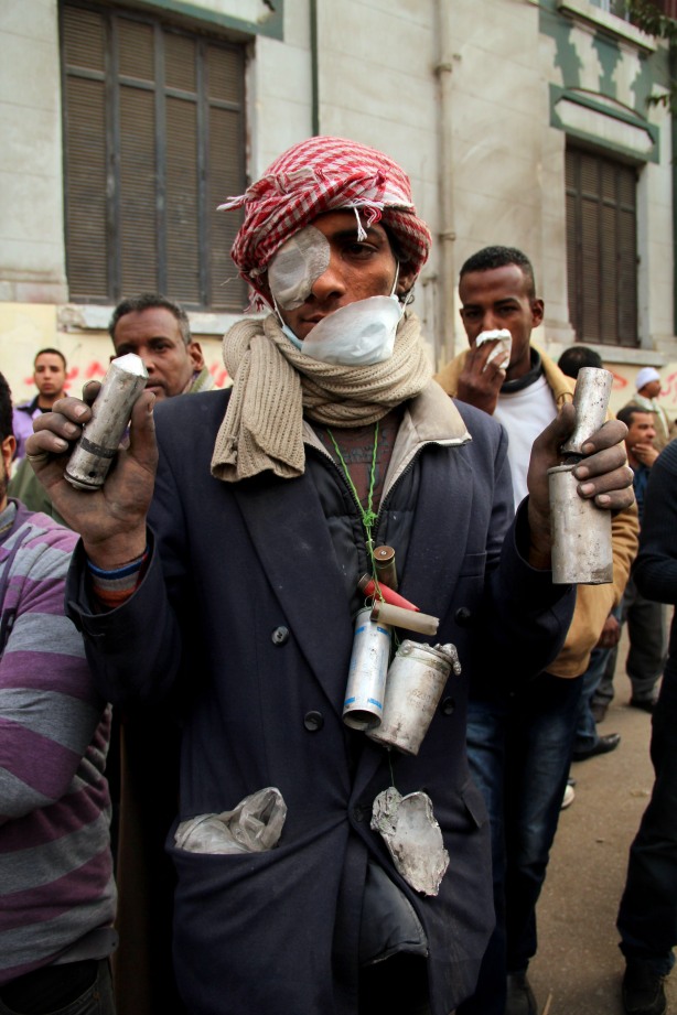 A protester wears teargas cans fired by security forces at the Interior Ministry in Cairo on Feb. 3rd, 2012. Some analysts say chemicals in the teargas have been internationally prohibited since 1993. (Photo by  Hamada Elrasam)