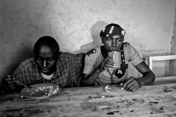 Van-sing, a 20 years old (R) drinks while he shares a meal with his friend Nshizirungu Amos 20 years old (L) in Chez Mama Fan resturant in Gibiloso, Kigali, Rwanda. Wed, Nov 13, 2013. Vansing knows  Nshizirungu Amos since he scaped the orphanage. Van-Sing says "Life in Giblioso is like jail but we have to share."  (Photo/Hamada Elrasam)